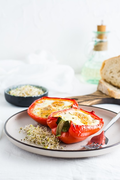 Mitades de pimiento al horno con huevo y microvegetales en un plato sobre la mesa Dieta orgánica flexitariana Vista vertical Copiar espacio