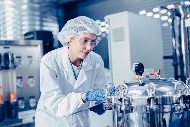 Foto mitarbeiter arbeiten in wissenschaftlichen medizinischen laboratorien fabrik überprüfen aufzeichnung druck tank glücklich arbeiten