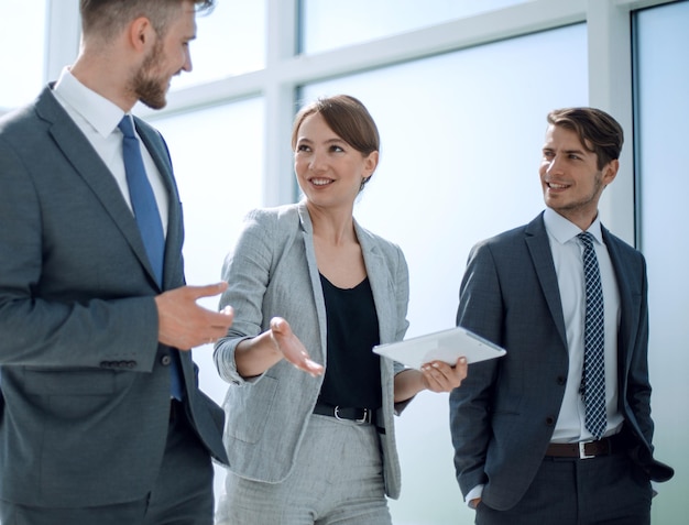 Mitarbeiter besprechen etwas im Büro stehendes Personal und Technik