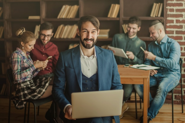 Mitarbeiter der Firma mit einem Laptop und einem Business-Team diskutieren