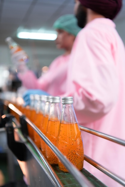 Foto mitarbeiter der produktqualitätskontrolle an der fruchtsaft-produktionslinie führen die qualitätskontrollen der produkte durch