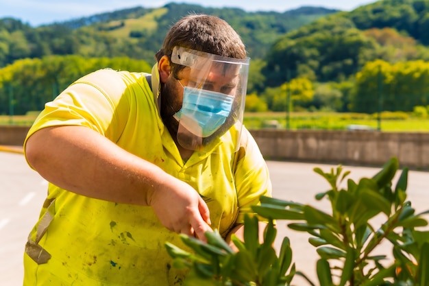 Mitarbeiter des Reinigungszentrums mit Gartenschere