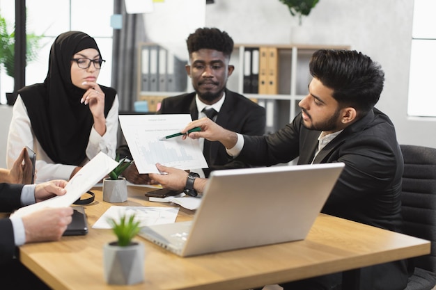 Mitarbeiter des Unternehmens, die im Büro einen Online-Anruf auf dem Laptop haben