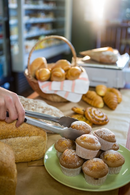 Mitarbeiter, die Tasse Kuchen mit einer Zange aufheben