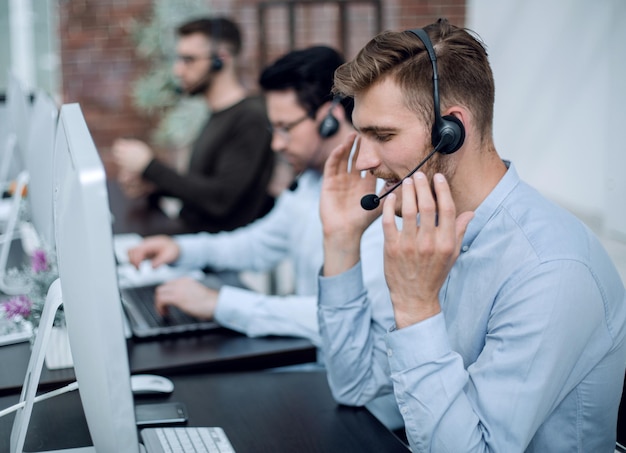 Foto mitarbeiter mit einem headset am arbeitsplatz im business centerbusiness-konzept