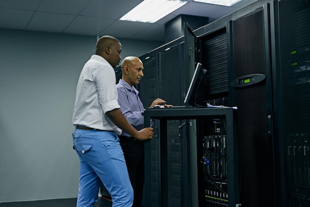 Mitarbeiter oder Techniker im Serverraum programmieren gemeinsam am Computer für einen Cybersicherheitsfehler, arbeiten gemeinsam mit IT-Supportcodes zusammen oder Ingenieure reparieren das PC-Netzwerk für die Informationstechnologie