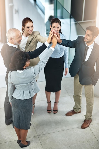 Mitarbeitermotivation ist der Schlüssel zu einer angenehmen Bürokultur Aufnahme einer Gruppe von Geschäftsleuten, die ein High-Five geben