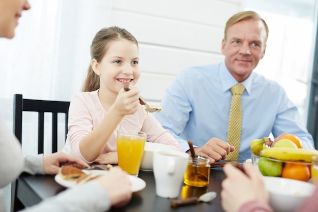 Mitglieder der schönen Familie, die frühstückt