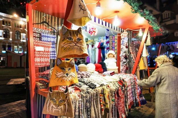 Mitones, guantes, calcetines y sombreros de colores cálidos en uno de los puestos del mercado navideño de la calle en Riga, Letonia. Consumidor en busca de un regalo