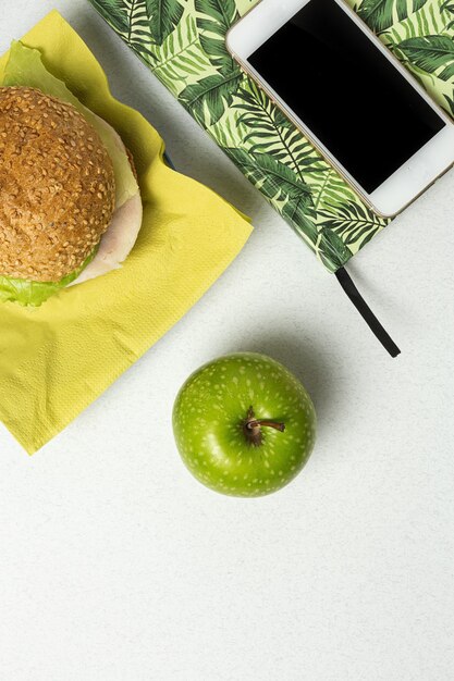 Mittagessen am Arbeitsplatz gesundes Sandwich nahe Laptop auf Arbeitstisch. Hauptnahrungsmittel für Bürokonzept