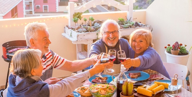 Mittagszeit älterer Lebensstil Gruppe von Senioren im Ruhestand Toasten und Feiern Urlaub Urlaub außerhalb Essen und Trinken am Tisch Glück und Freundschaft Männer und Frauen im reifen Alter