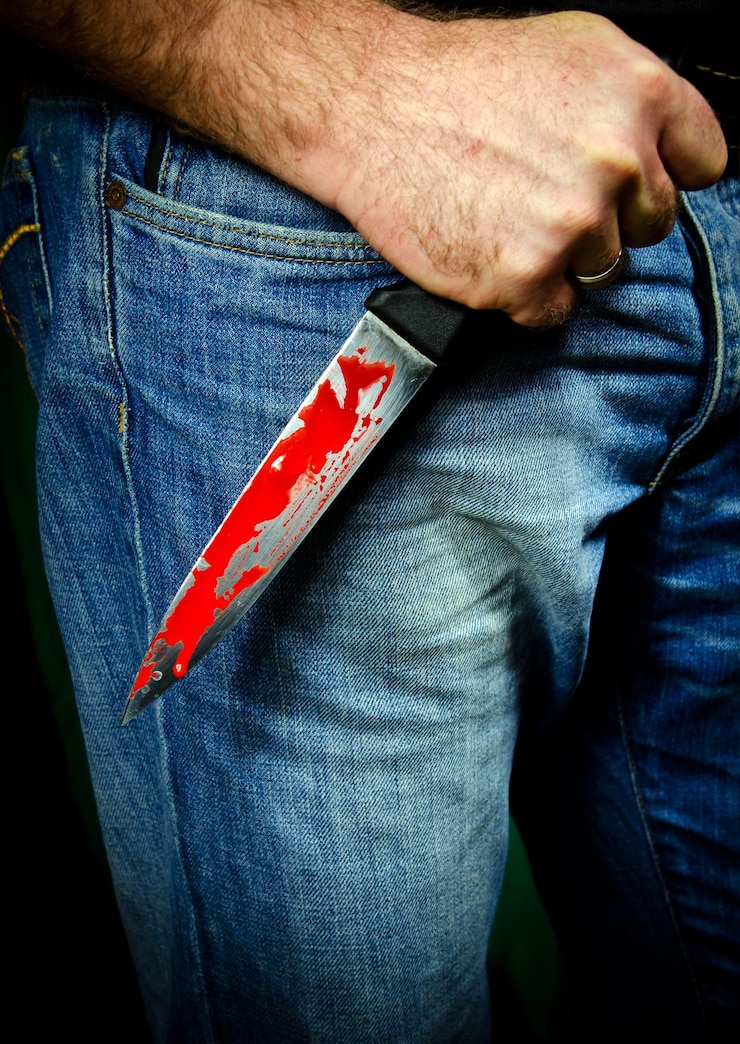 Foto mittelabschnitt des mörders, der ein blutiges messer hält