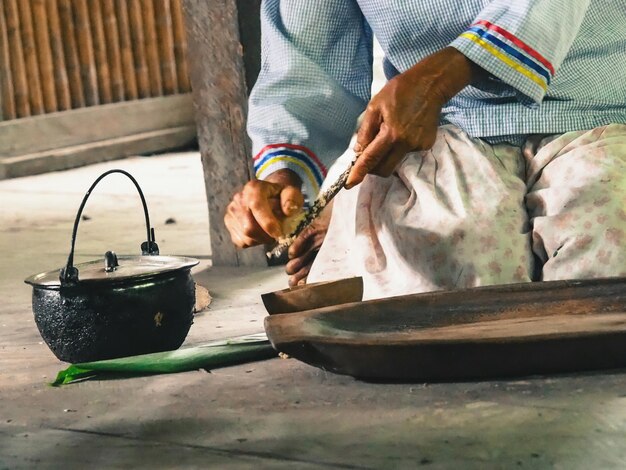 Foto mittelabschnitt einer frau, die auf dem boden kniend essen zubereitet