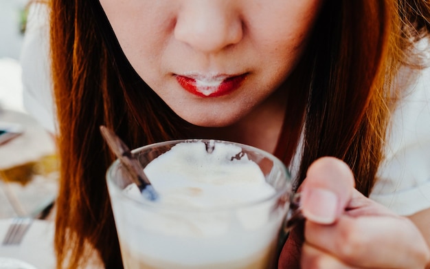 Foto mittelabschnitt einer frau, die ein getränk in einem becher trinkt