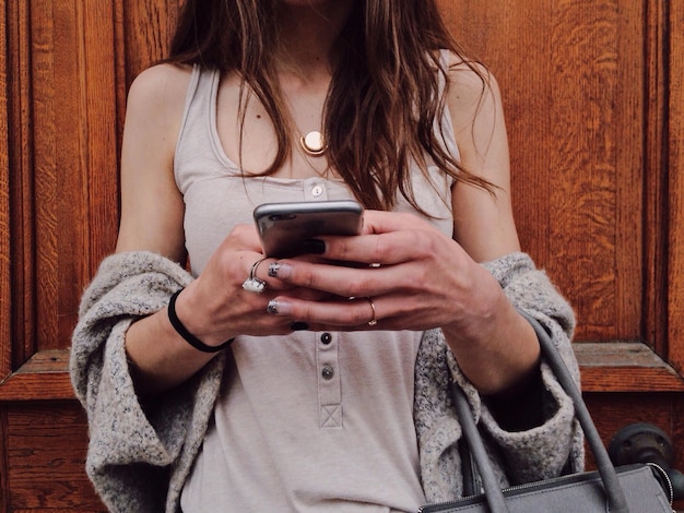 Mittelabschnitt einer Frau, die ein Handy benutzt