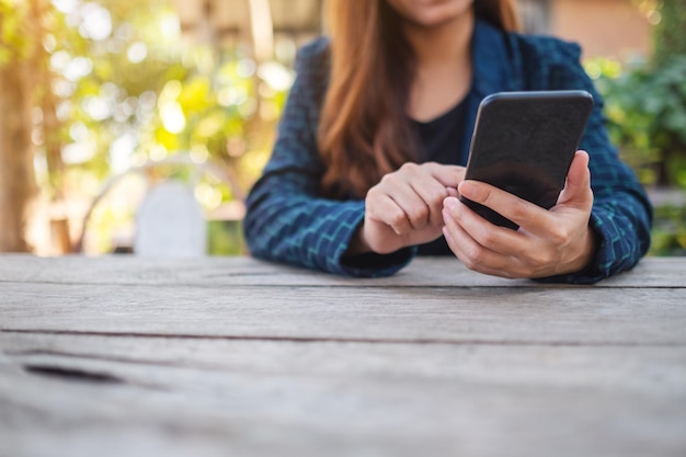 Foto mittelabschnitt einer frau, die ein mobiltelefon benutzt