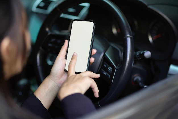 Mittelabschnitt einer Frau, die ein Mobiltelefon im Auto benutzt