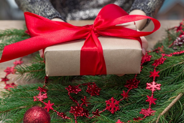 Mittelabschnitt einer Frau, die ein Weihnachtsgeschenk am Tisch hält