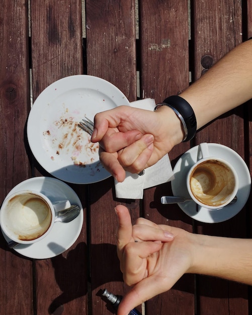 Mittelabschnitt einer Frau, die eine Kaffeetasse auf dem Tisch hält