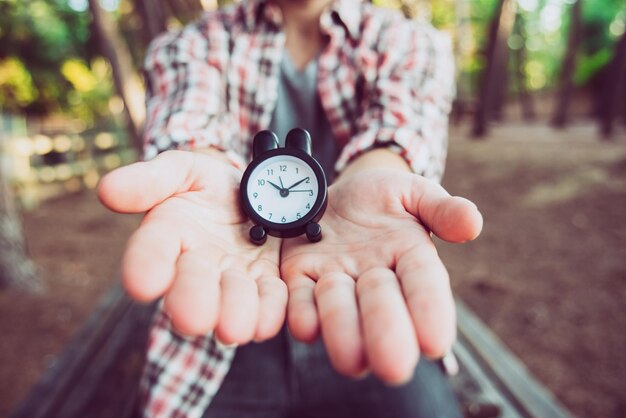 Foto mittelabschnitt einer frau, die eine uhr hält