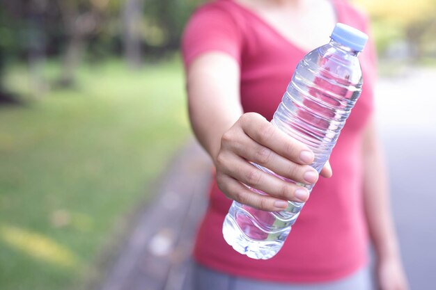 Foto mittelabschnitt einer frau, die eine wasserflasche hält