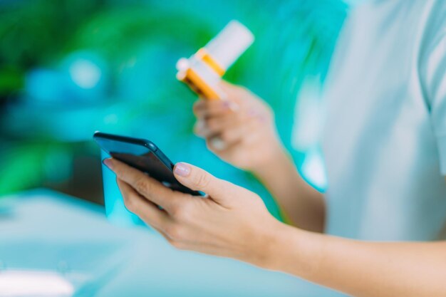 Foto mittelabschnitt einer frau, die einen asthma-inhalator und ein handy auf dem tisch hält