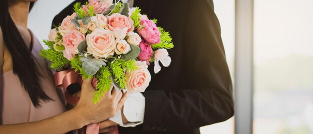 Mittelabschnitt einer Frau, die einen Blumenstrauß hält