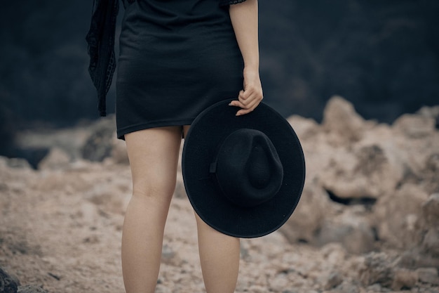 Mittelabschnitt einer Frau, die einen Hut hält, während sie an Land steht