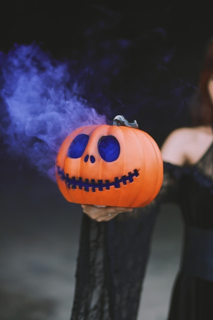 Mittelabschnitt einer Frau, die einen Jack-o-Lantern hält