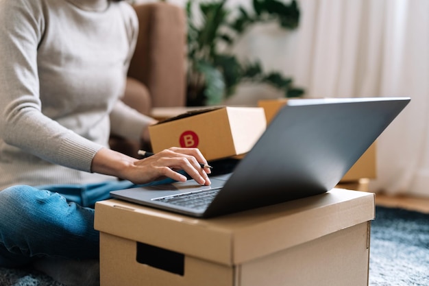 Mittelabschnitt einer Frau, die einen Laptop am Tisch benutzt