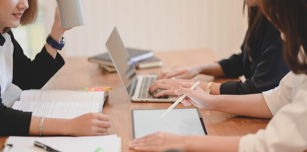 Mittelabschnitt einer Frau, die einen Laptop auf dem Tisch benutzt