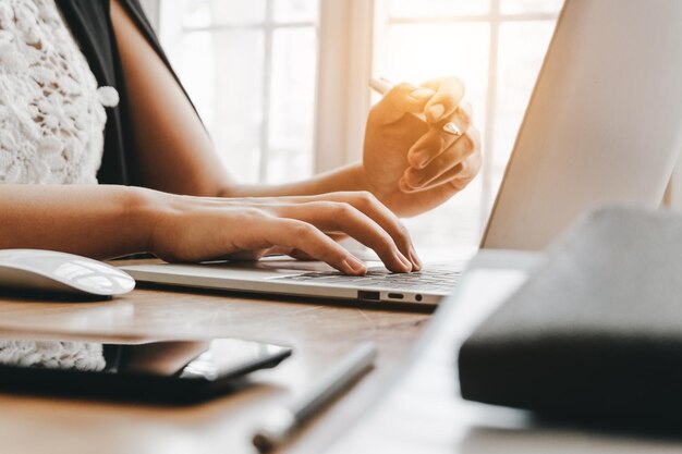 Foto mittelabschnitt einer frau, die einen laptop auf dem tisch benutzt