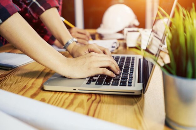 Foto mittelabschnitt einer frau, die einen laptop auf dem tisch benutzt