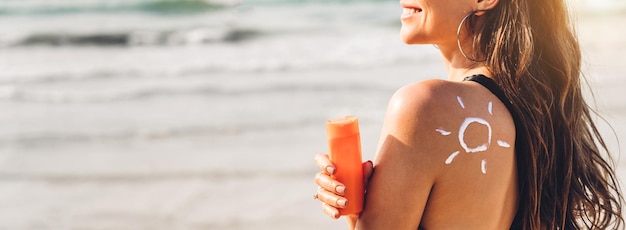 Mittelabschnitt einer Frau, die einen Regenschirm am Strand hält