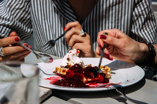 Foto mittelabschnitt einer frau, die essen auf dem tisch hält