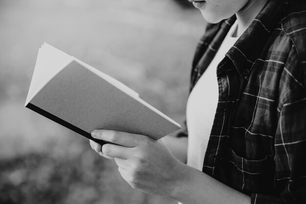 Foto mittelabschnitt einer frau, die im freien ein buch liest