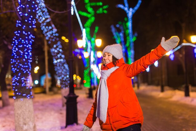 Foto mittelabschnitt einer frau, die nachts im winter bei einem beleuchteten licht steht