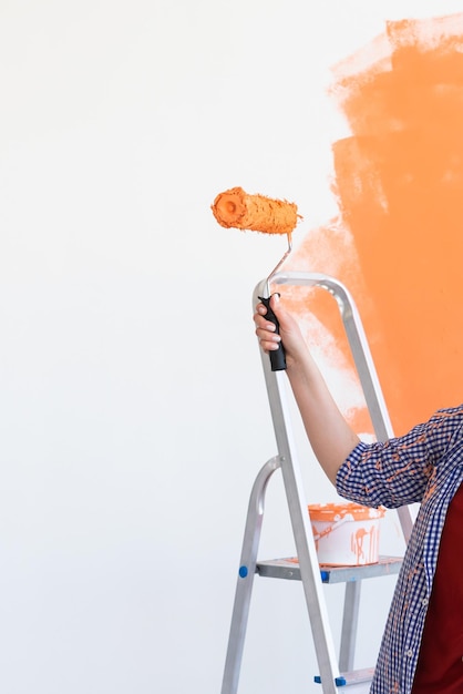 Mittelabschnitt einer Frau, die Orange vor weißem Hintergrund hält