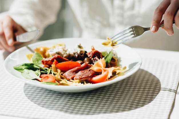 Mittelabschnitt einer Frau, die Salat im Restaurant isst