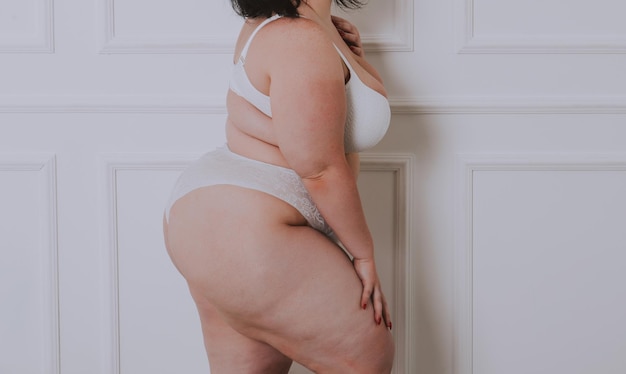 Mittelabschnitt einer Frau, die vor einem farbigen Hintergrund steht