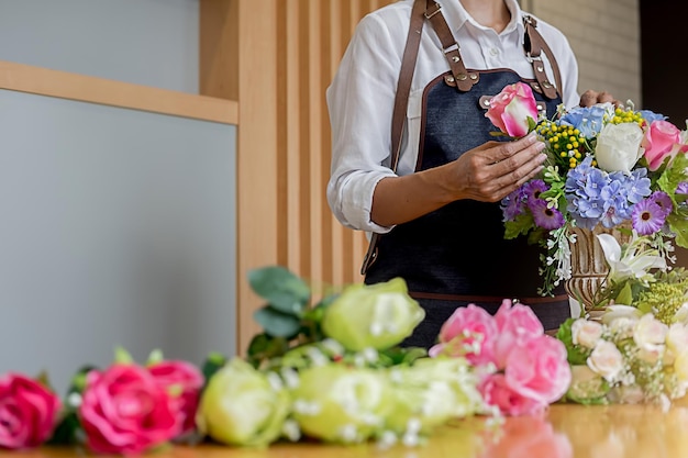 Foto mittelabschnitt einer frau, die zu hause blumen anpasst