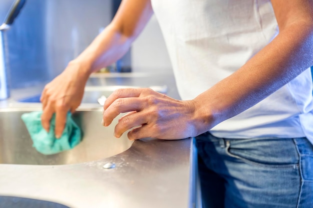 Foto mittelabschnitt einer frau, die zu hause das küchenbecken reinigt