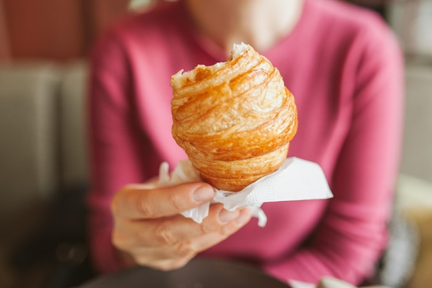 Foto mittelabschnitt einer frau, die zu hause einen croissant hält