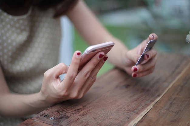 Mittelabschnitt einer Frau mit Telefon und Kreditkarte auf dem Tisch