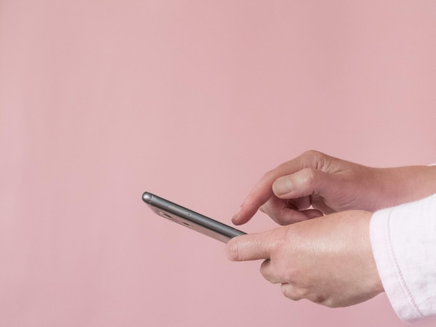 Mittelabschnitt einer Person, die ein Mobiltelefon hält
