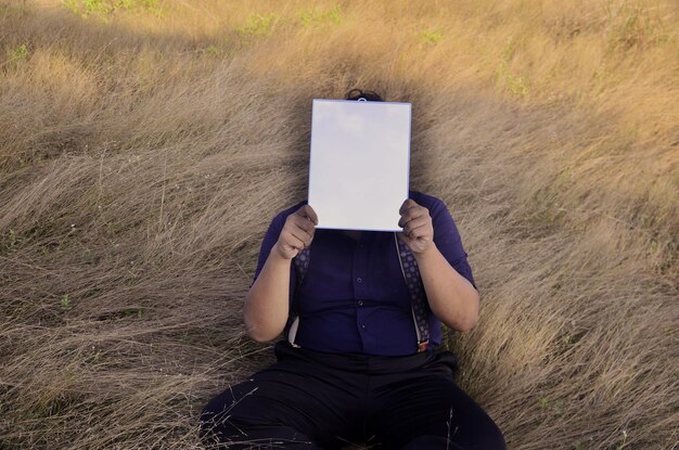 Foto mittelabschnitt einer person, die ein smartphone auf dem feld hält