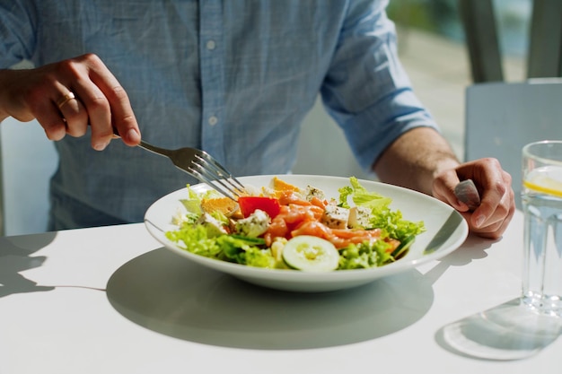 Mittelabschnitt einer Person, die eine Gabel im Restaurant hält