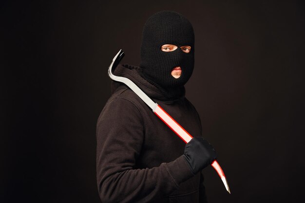 Foto mittelabschnitt einer person, die eine maske gegen einen schwarzen hintergrund trägt