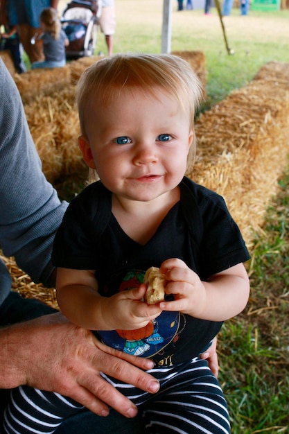 Foto mittelabschnitt einer person, die einen jungen auf dem gras hält