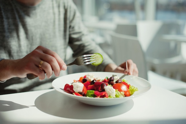 Mittelabschnitt einer Person, die in einem Restaurant Salat isst